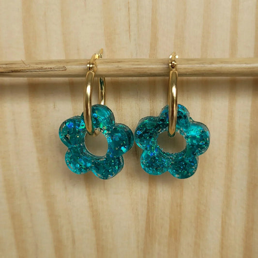 Boucles d’oreilles fleurs bleues en résine pailletée sur créoles dorées, bijoux fantaisie.