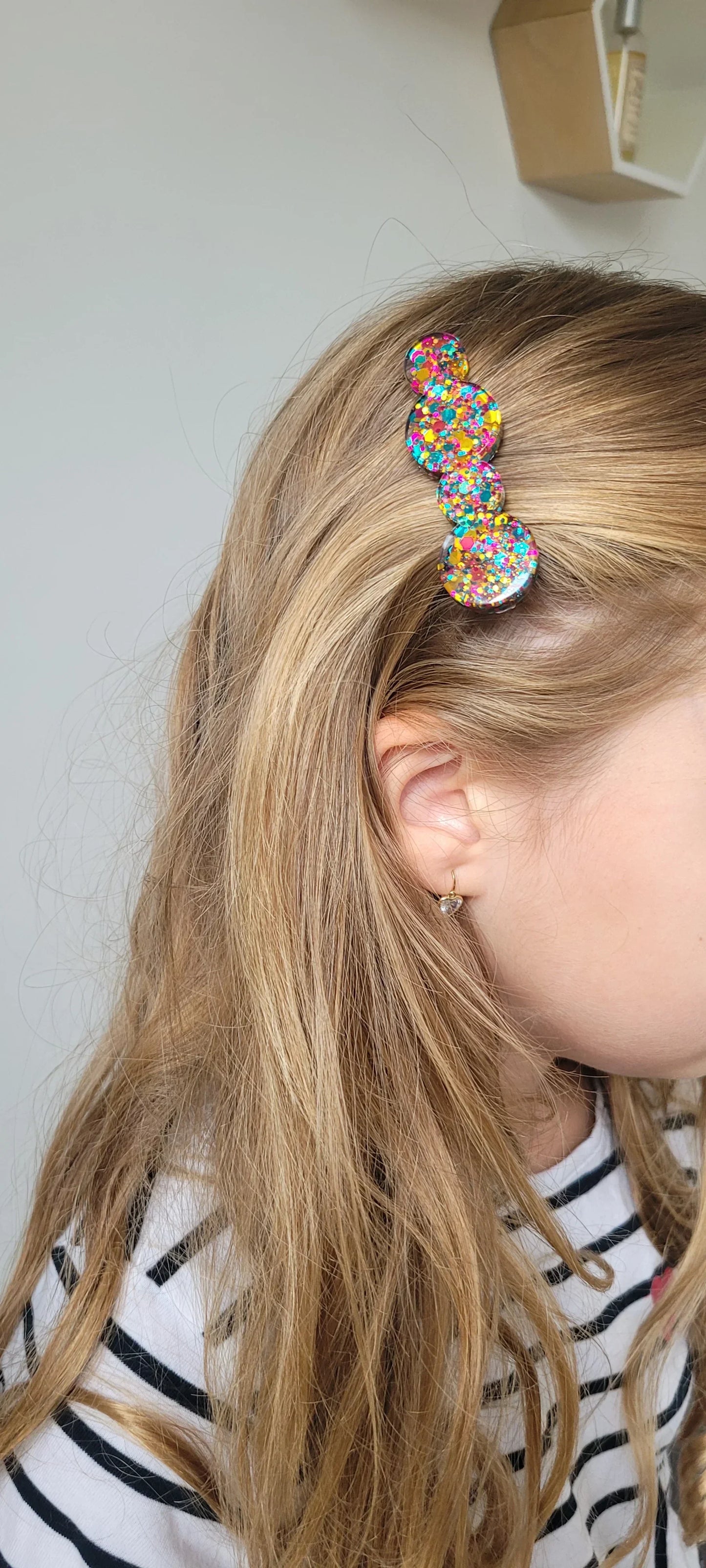Barrette en résine à paillettes colorées sur cheveux blonds, style fantaisie artisanal