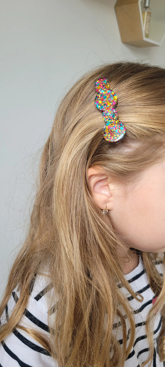 Barrette en résine à paillettes colorées sur cheveux blonds, style fantaisie artisanal