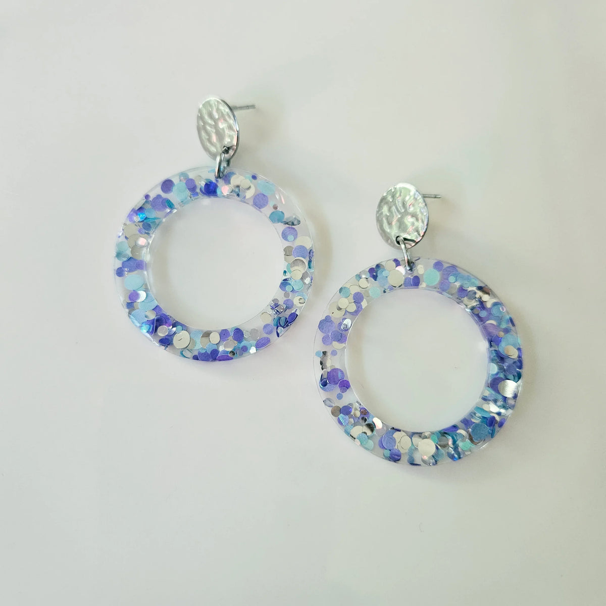 Boucles d'oreilles créoles en résine transparente avec paillettes violettes et bleues L'Atelier de MyMy